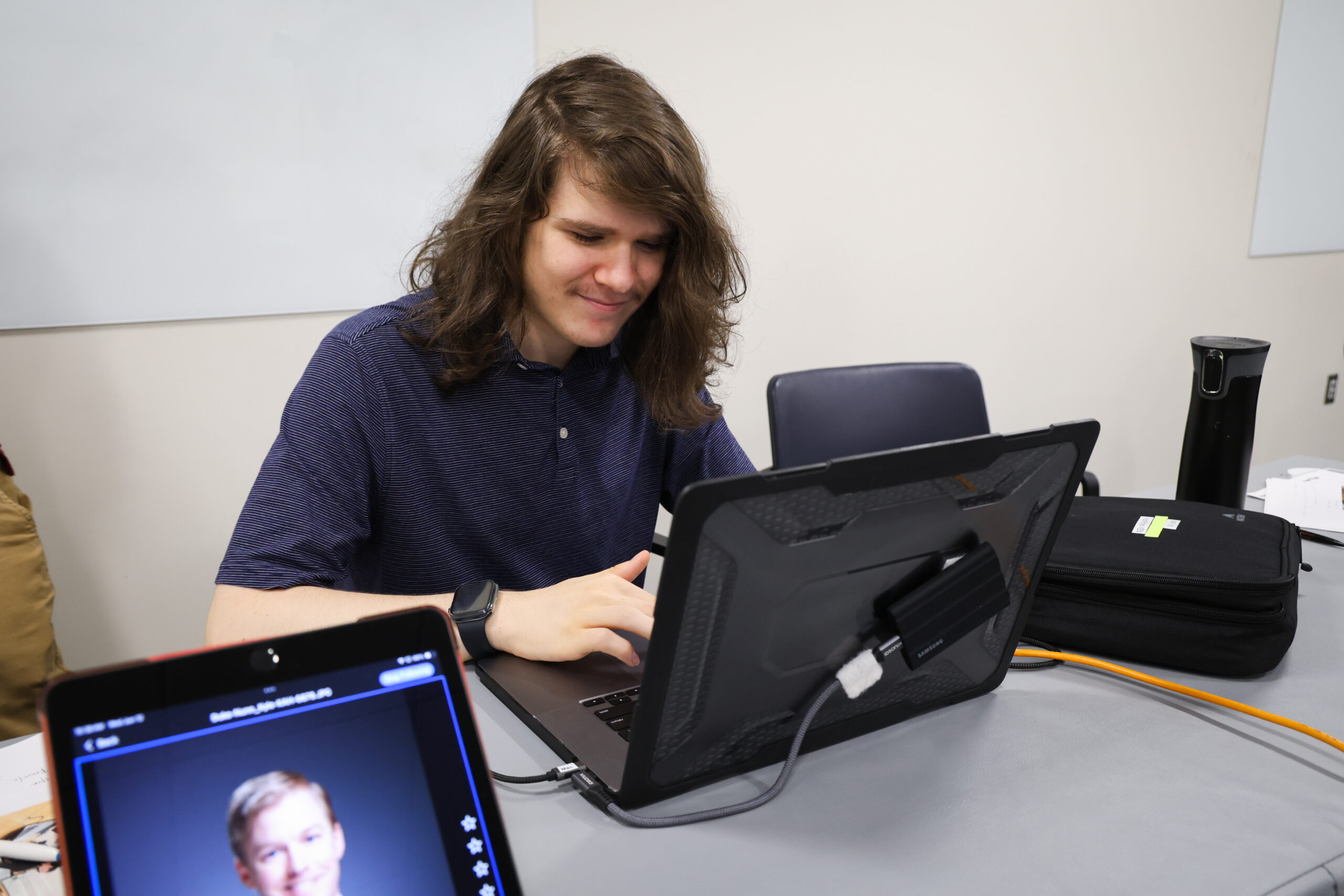 young man with long hair uses a Mac laptop. He is Oliver Huth